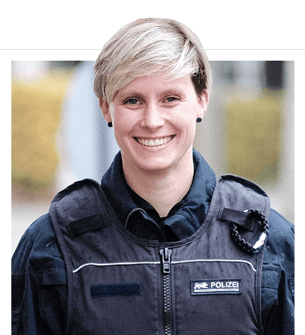 Eine blondhaarige Frau mit kurzen Haaren in Polizeiuniform